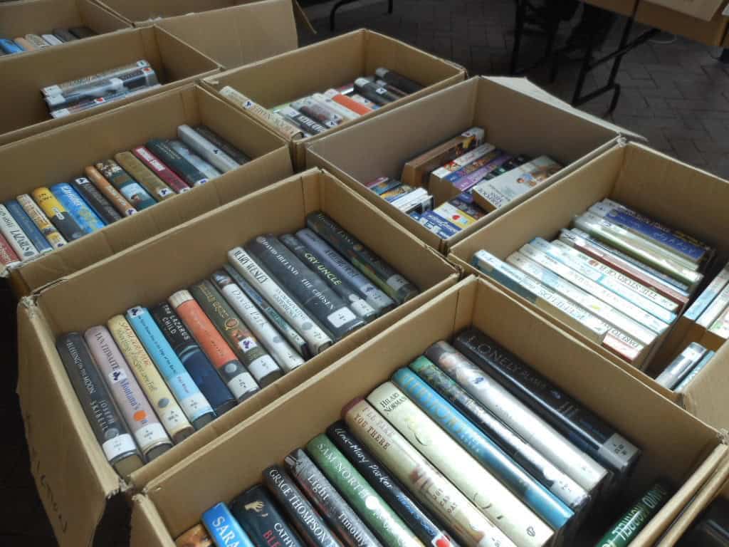 Boxes filled with assorted books for sale.
