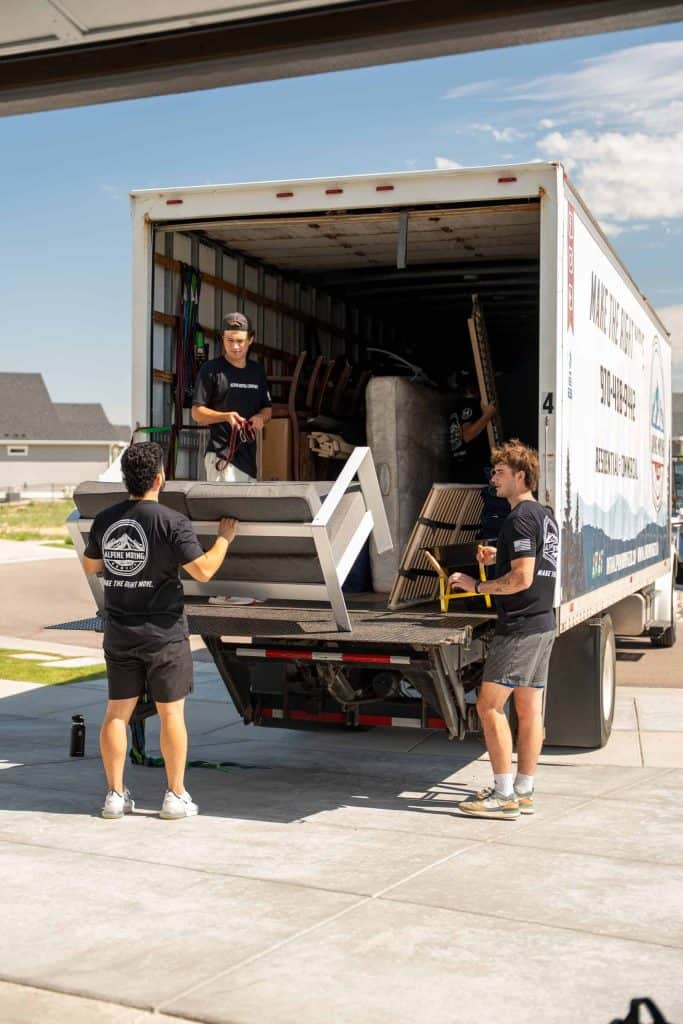 Movers loading furniture into truck for junk removal