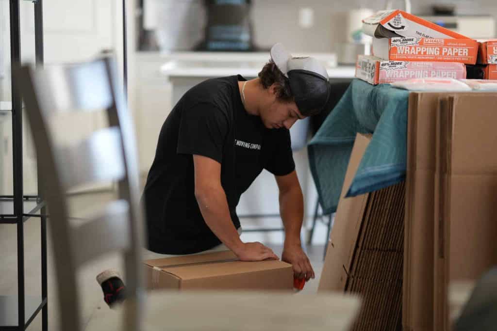 Person taping boxes for moving preparation.