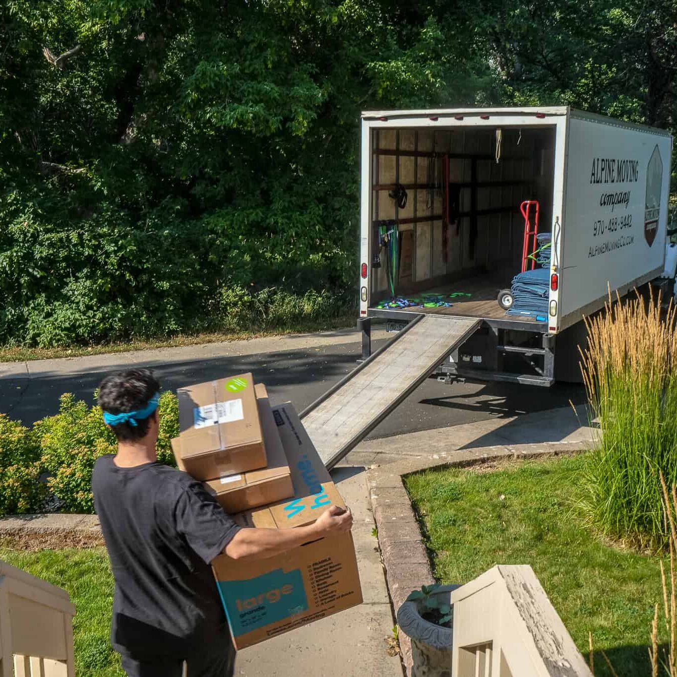 Person loading moving truck with boxes.