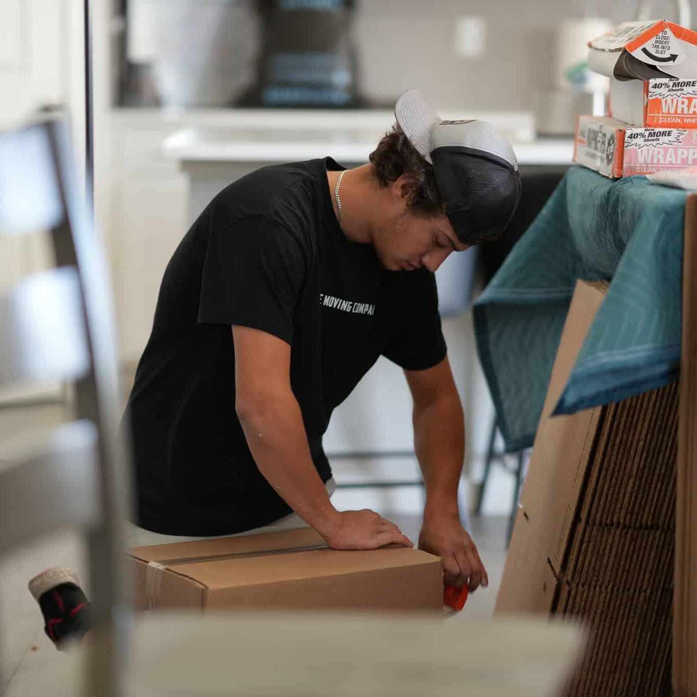 Person sealing boxes for moving preparation.