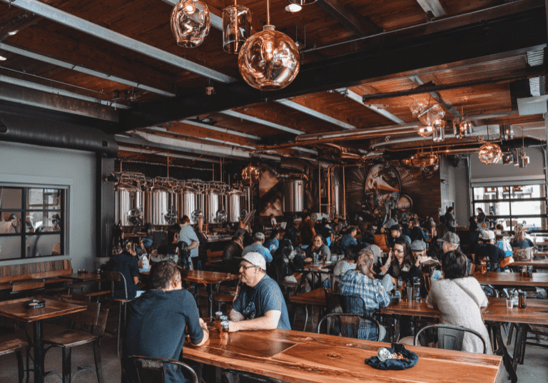 Busy brewery in Fort Collins with people enjoying drinks and conversation.