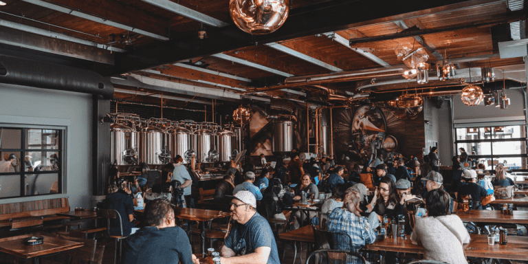 Busy brewery in Fort Collins with people enjoying drinks and conversation.