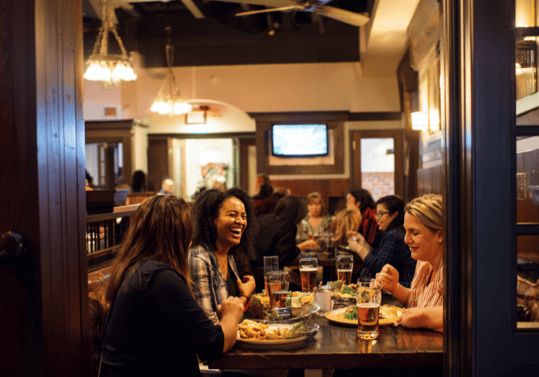 Friends laughing and dining in a lively restaurant