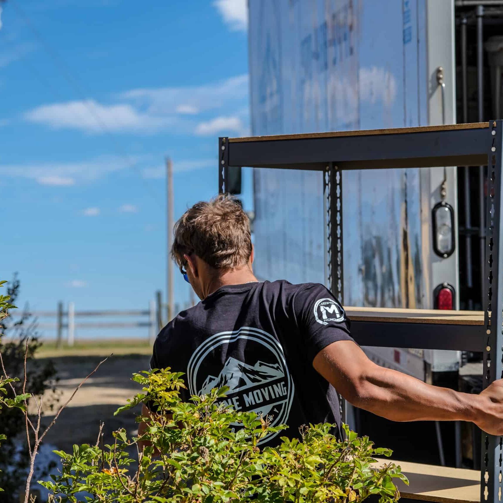Person moving metal shelf from truck