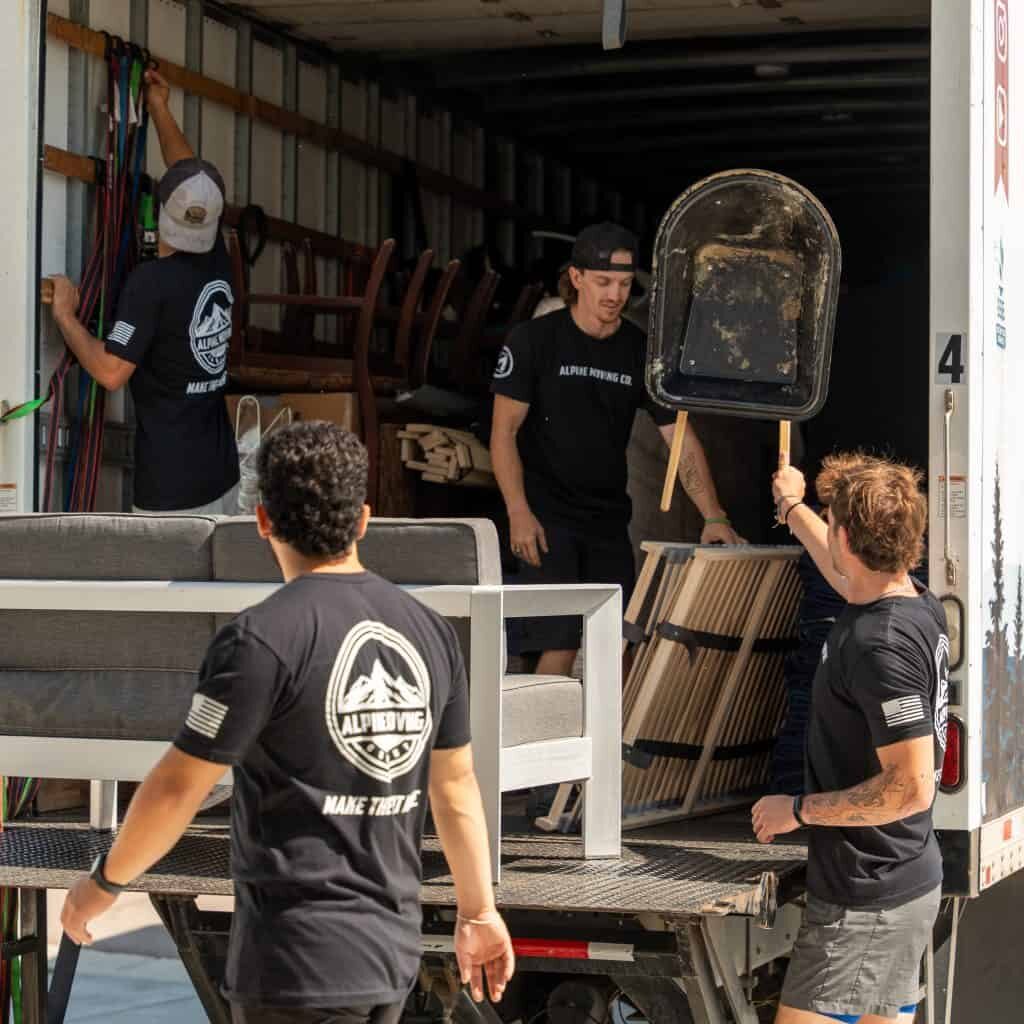 Workers unloading furniture from a moving truck.