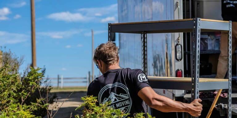 Mover hauling a shelving unit for junk removal services