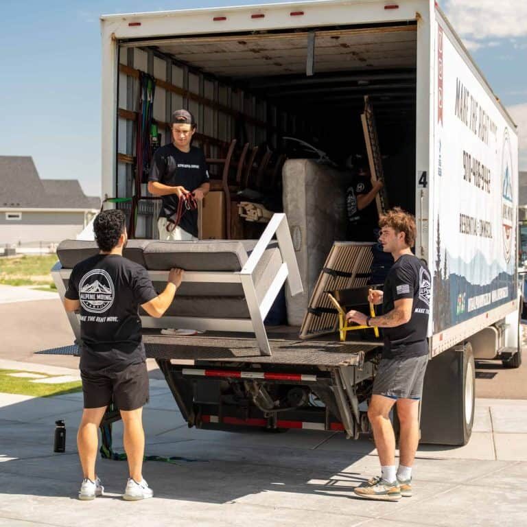 Movers loading furniture into truck for junk removal