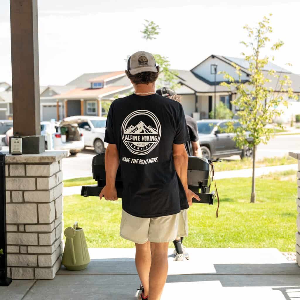 Person moving a grill on a porch.