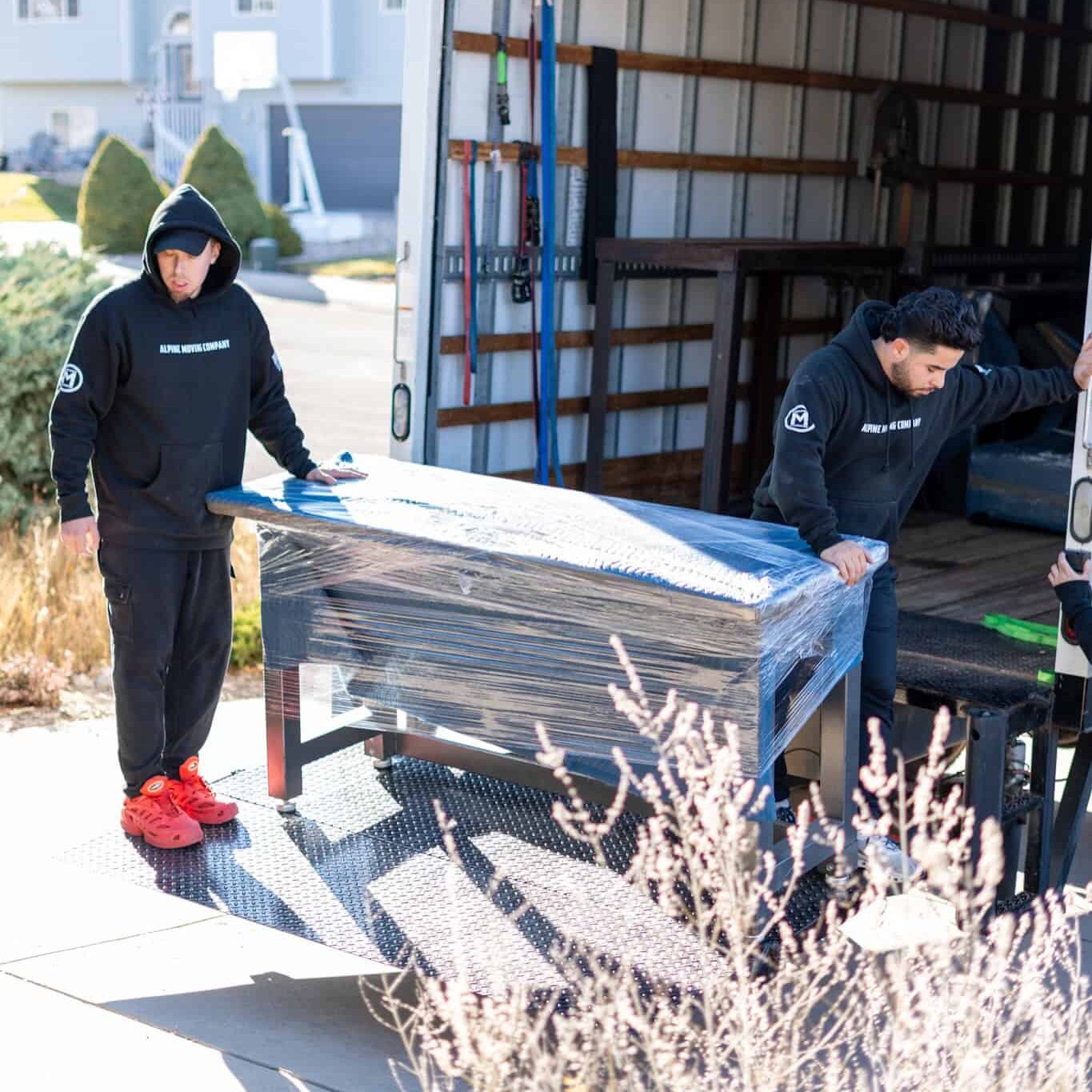 residential Movers loading furniture into truck on a sunny day.
